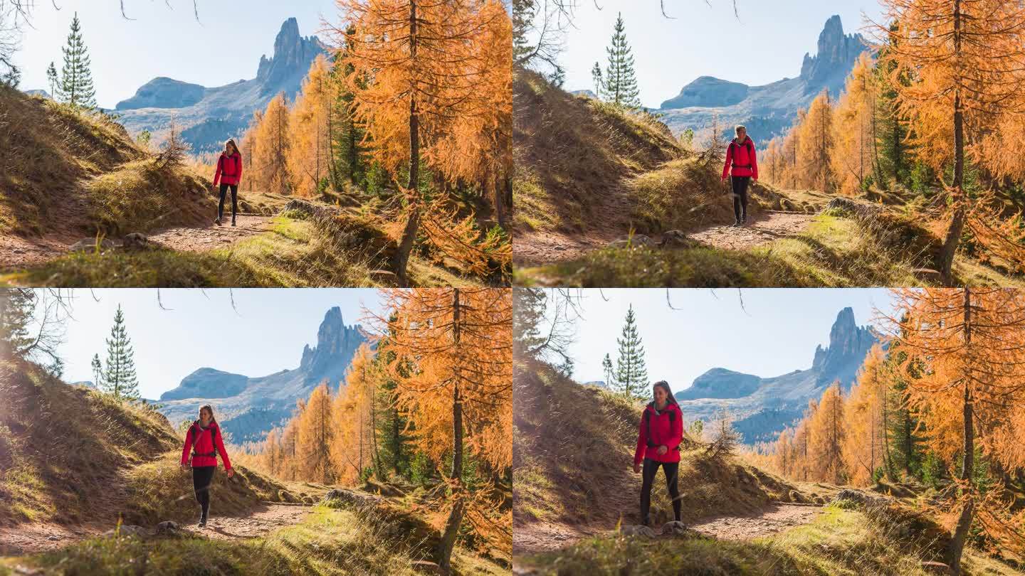 一名女子在秋天雄伟的山前徒步旅行