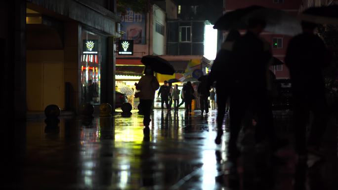 下雨的夜晚   城市行人打着伞下班回家