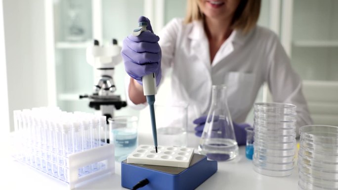 科学家在实验室用移液管分析液体提取DNA和分子