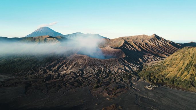 布罗莫山在清晨活跃地喷出火山烟雾。无人机时间推移轨道与良好的光线显示这个地标火山的轮廓，爪哇，印度尼