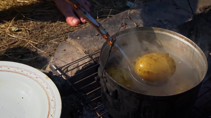 土豆在白天用大锅在明火上煮