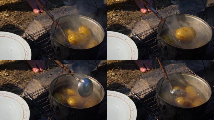 土豆在白天用大锅在明火上煮