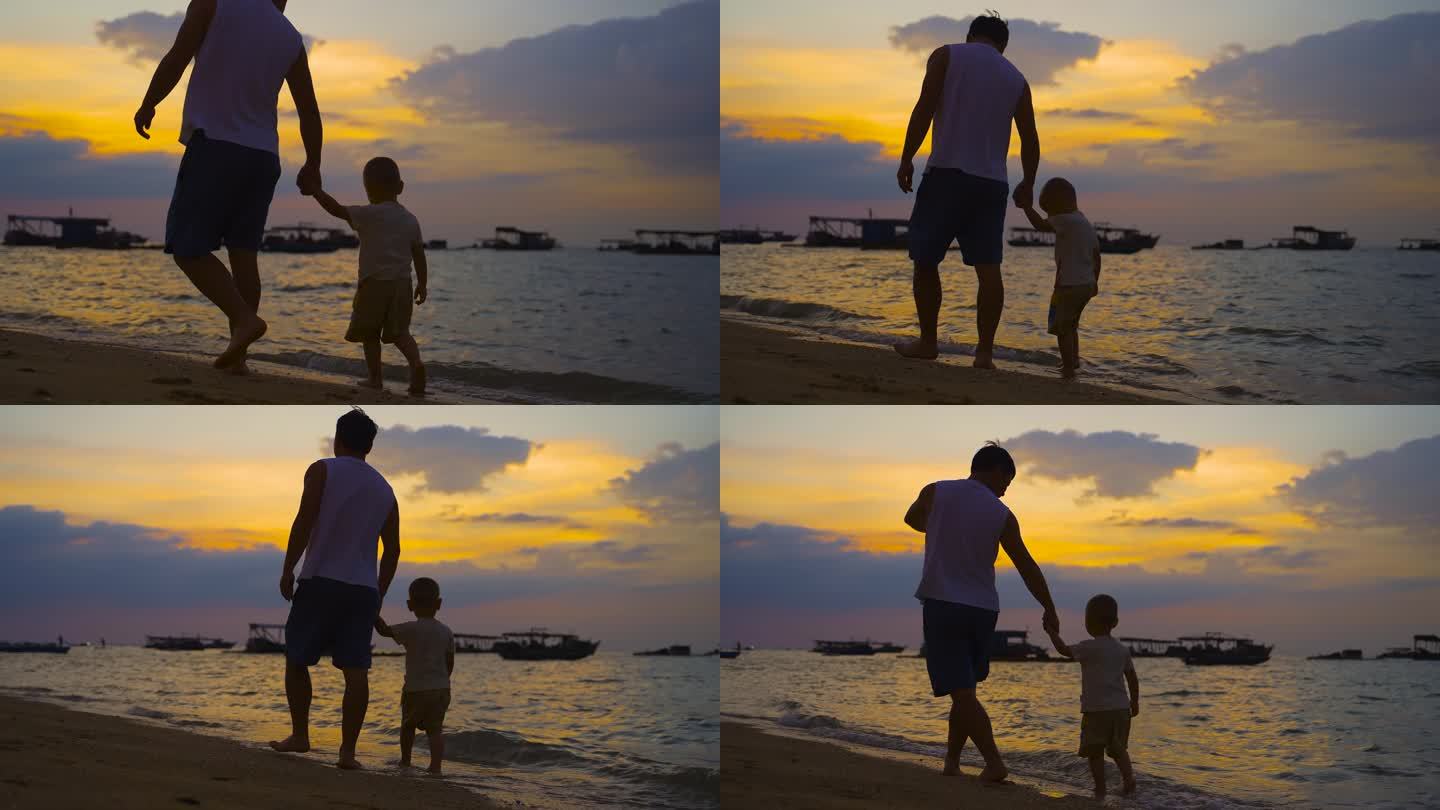 父子海边散步温馨爸爸牵着儿子海边日落夕阳