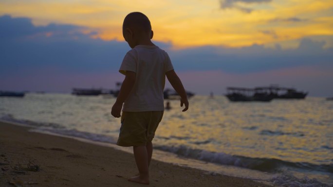 小男孩一个人独自海边散步孤独幼小的身影