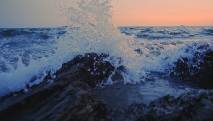早晨夕阳海浪浪花冲击岩石