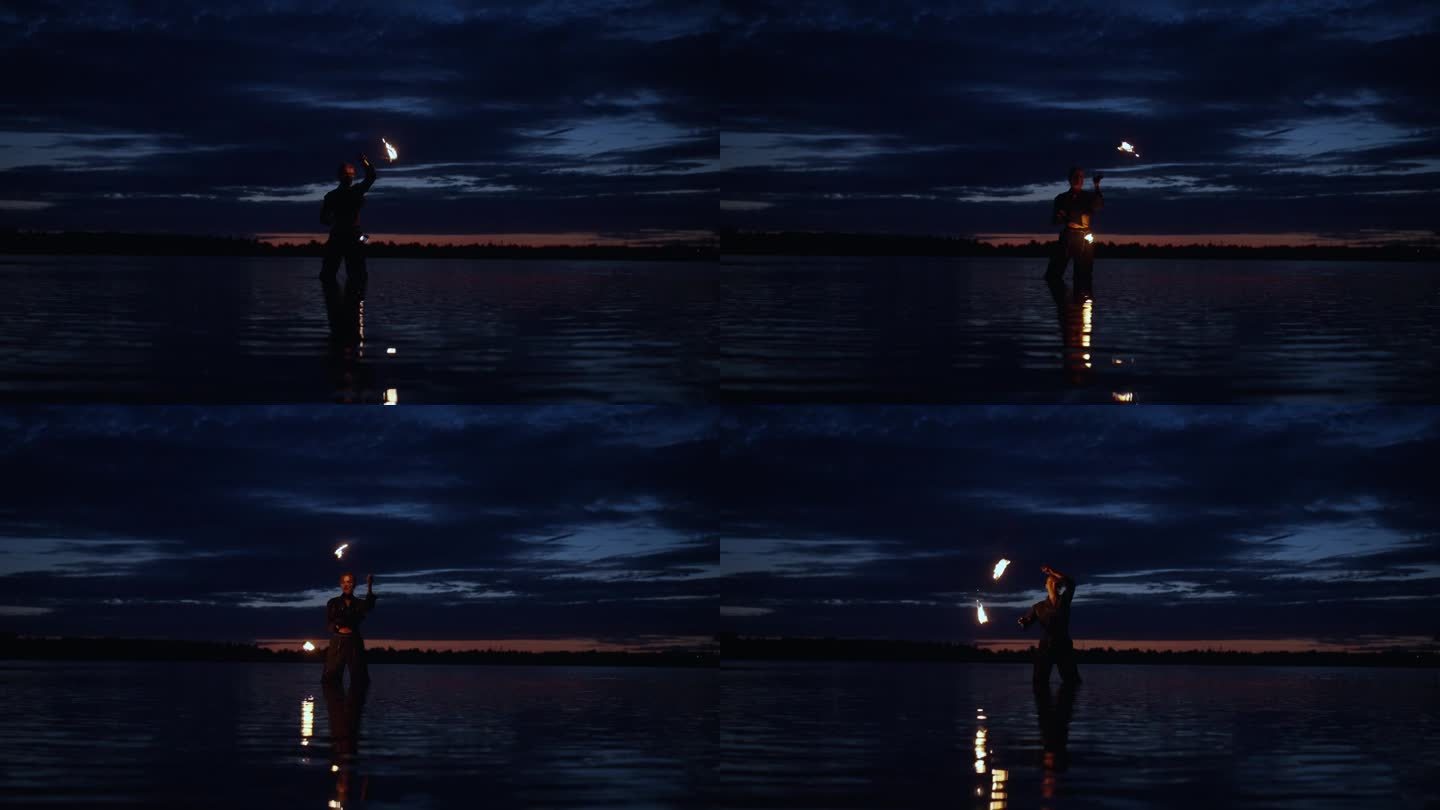 女人在夜晚玩弄燃烧的火把的剪影，女人站在河里玩火