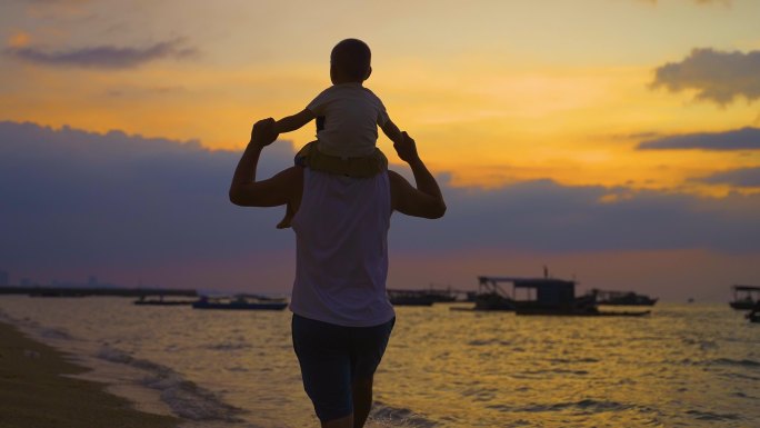 父子素材-日落年轻爸爸肩扛着儿子海边散步