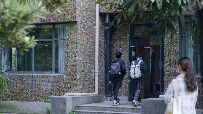 大学生行走在校园的上课路上骑自行车