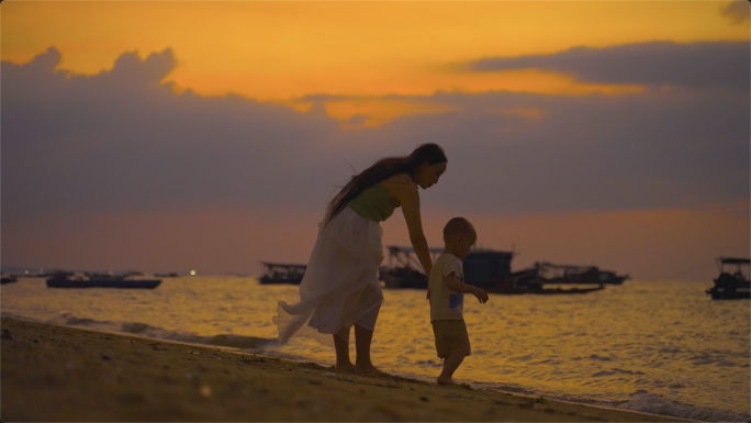 唯美日落在海边玩耍的母子休闲温馨旅游度假