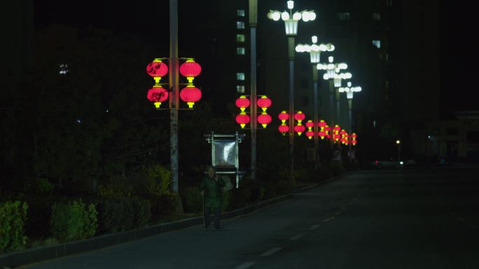 深夜背着行李走在城市道路上的老人