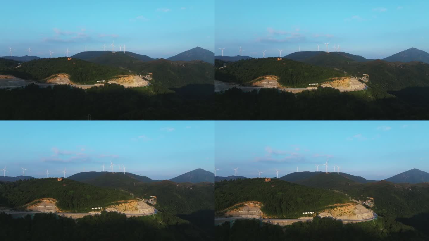 航拍崇山峻岭间山顶的水库与风力发电场风机