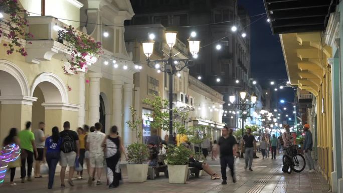 多米尼加共和国，圣多明各——2023年7月17日:夜晚，人们在路灯的照耀下走过殖民城的Calle E