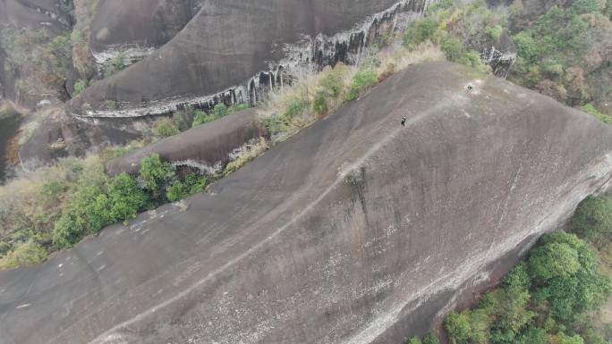 航拍男人站在山脊高椅岭刀背山顶悬崖峭壁