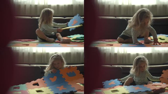 女孩在家里玩教育字母玩具垫子。