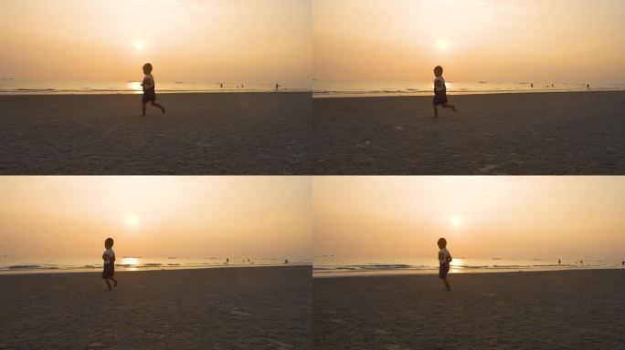日落小男孩海边奔跑傍晚男孩光脚沙滩上跑步
