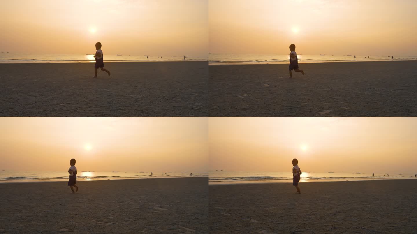 日落小男孩海边奔跑傍晚男孩光脚沙滩上跑步