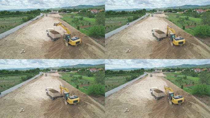 工业挖掘机将公路施工现场的土料装入自卸车