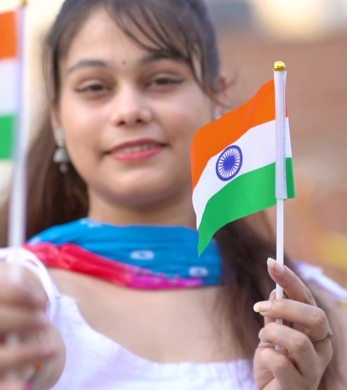 兴高采烈的印度年轻女子手持两面印度国旗庆祝独立日。