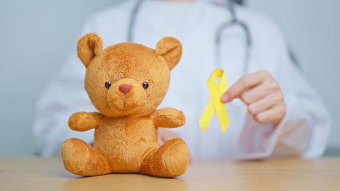国际儿童癌症宣传月，儿童医生玩具及金色丝带，支持儿童生活。保健和世界癌症日概念