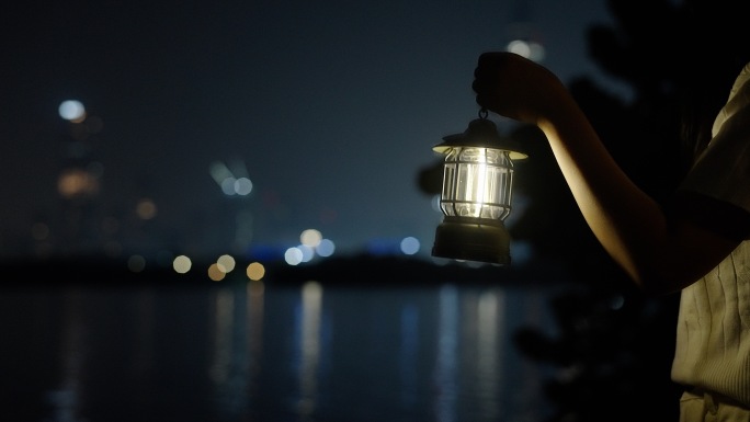 夜晚女孩提着马灯走在河边