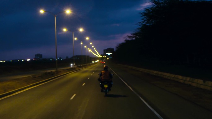 夜晚摩托车行驶路灯
