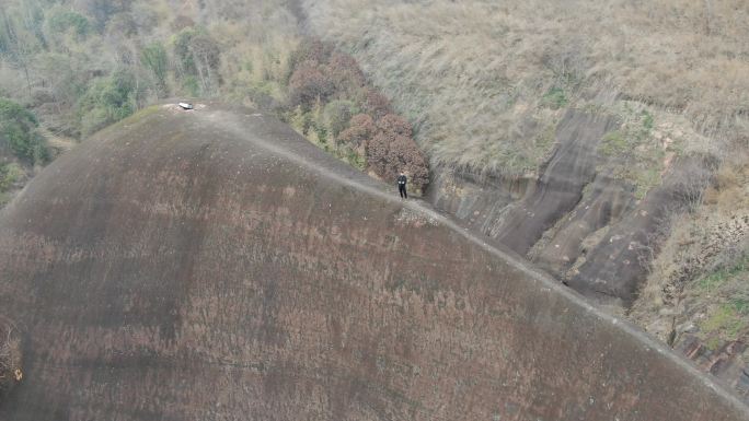 航拍男人站在山脊高椅岭刀背山顶悬崖峭壁