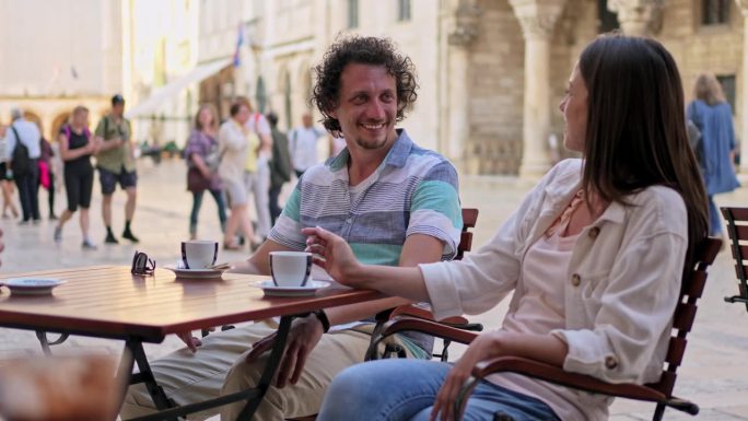 一对年轻夫妇在杜布罗夫尼克的路边咖啡馆喝咖啡