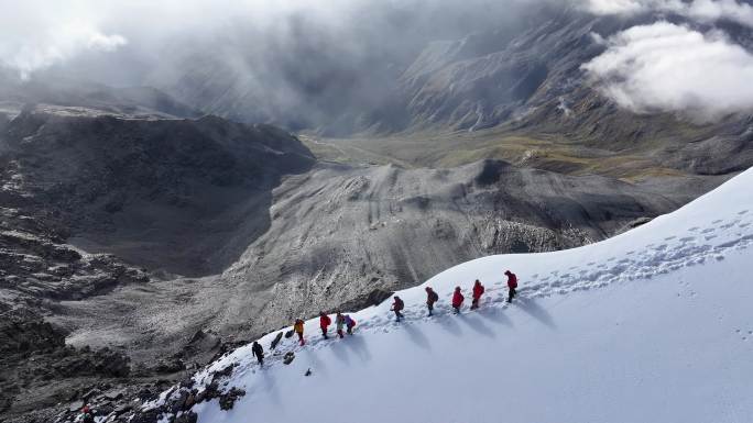 航拍攀登贡嘎山卫峰乌库楚雪山上的登山者