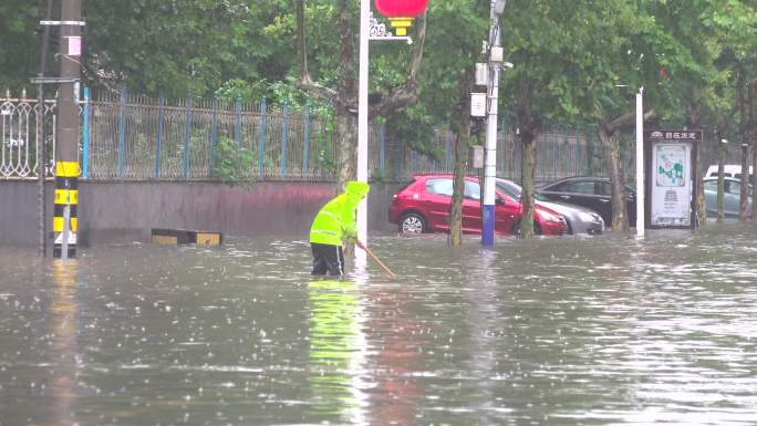 大雨中疏通下水道的环卫工人