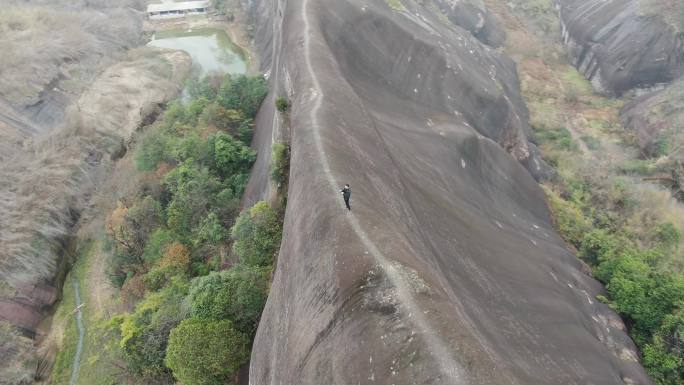 航拍男人站在山脊高椅岭刀背山顶悬崖峭壁