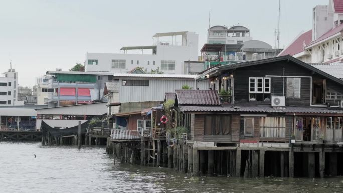 泰国曼谷- 2023年7月20日:曼谷河岸上的木制房屋。这个地区居住着华人社区。滨江，滨河景观，传统