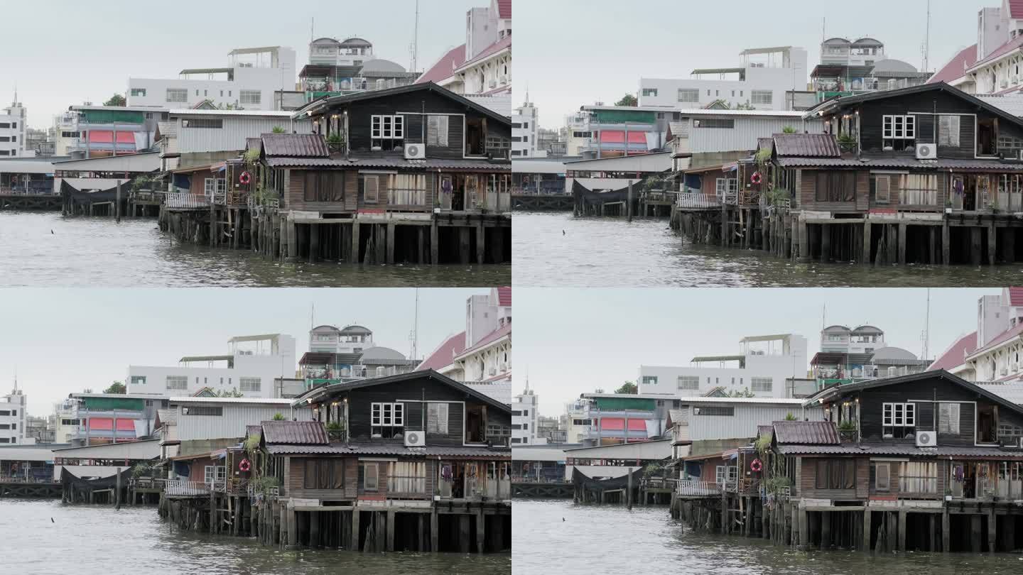 泰国曼谷- 2023年7月20日:曼谷河岸上的木制房屋。这个地区居住着华人社区。滨江，滨河景观，传统