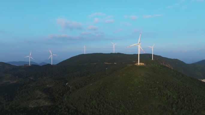 航拍崇山峻岭间山顶的水库与风力发电场风机