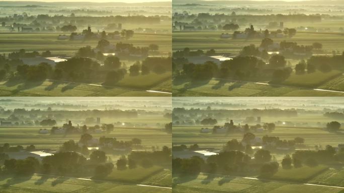 清晨日出时，美国乡村农田上的雾气、薄雾和露水。玉米田、农场、谷仓、筒仓和树木的空中拍摄。