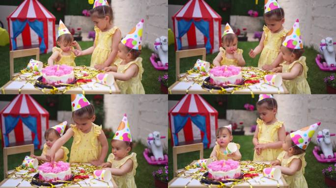 一对双胞胎姐妹和一个姐姐一起庆祝她们的一岁生日