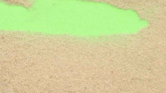 特写的沙子过渡吹过绿色的屏幕背景