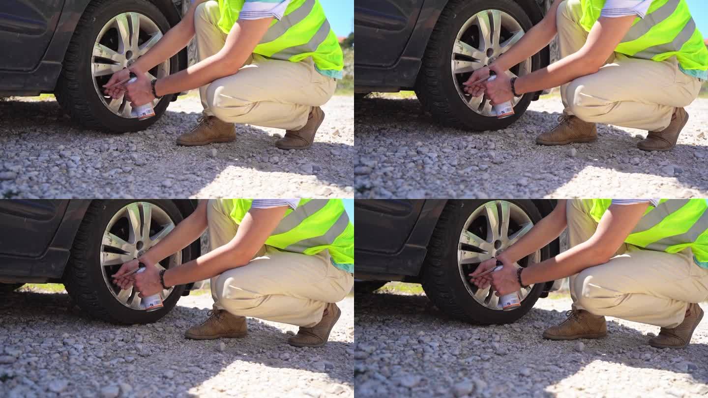 一个穿着反光衣服的人在公路旅行中修理漏气的轮胎