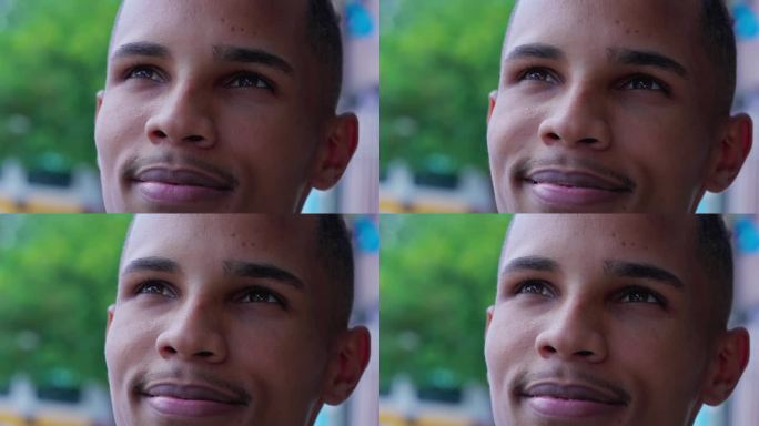 一个巴西黑人青年满怀希望和信念仰望天空。沉思的南美男性带着快乐的表情，仰望着近距离的脸