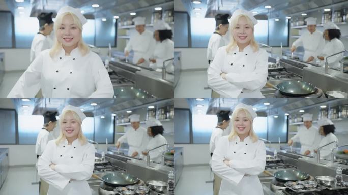 微笑的中国女厨师代表他们的烹饪团队，支持团队团结，专业烹饪团队在酒店餐厅厨房准备食物时快乐的时刻