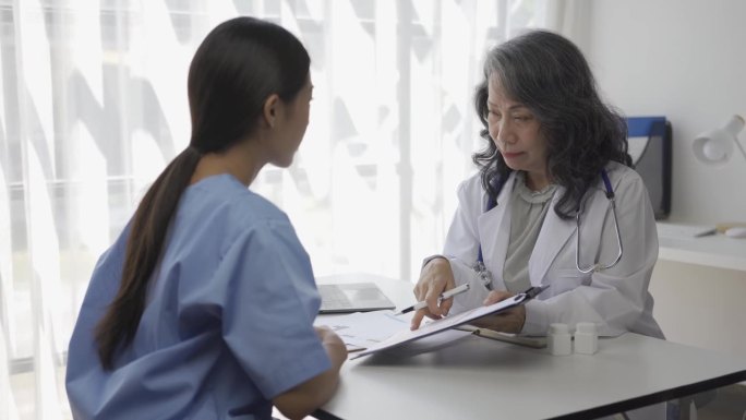 在医院的观察室，一位资深女医生正在给医学生们讲解病人的各种疾病。