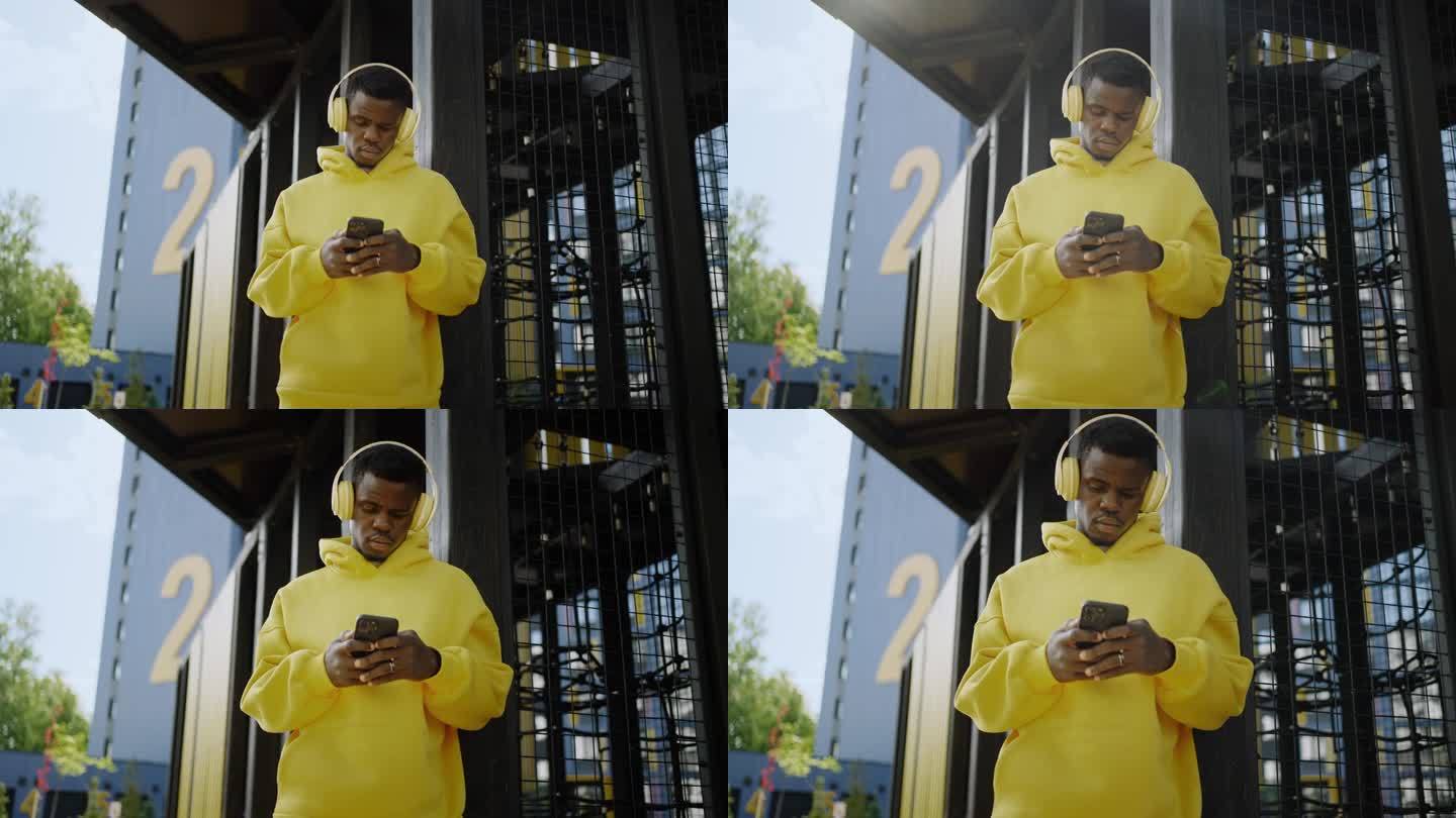 夏日里，城市里英俊的黑人男子，用智能手机拍摄的非洲人的肖像