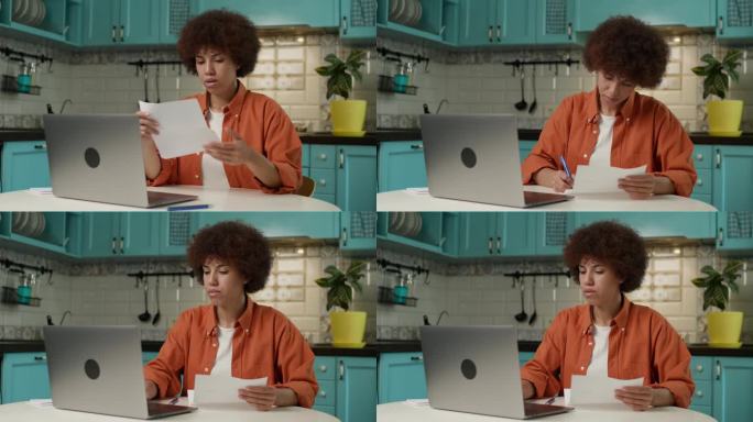 黑人女性用笔记本电脑打字，30多岁的企业家，在家办公室管理文件、发票、税单。