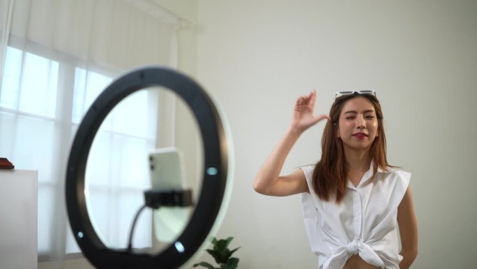 亚洲年轻女性网红在社交媒体上分享舞蹈内容和故事。博主们在家里用智能手机为社交网络制作了她的舞蹈视频。