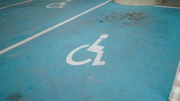 超市或商场内为残障司机预留的停车场。残障人士停车位。沥青停车场的轮椅标志油漆。残疾人停车场。