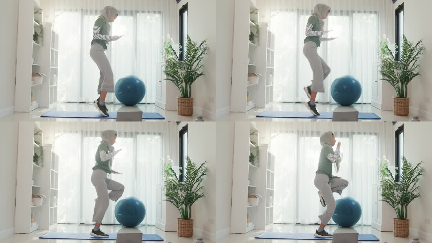 运动亚洲伊斯兰妇女穿穆斯林运动服锻炼全身锻炼高膝初学者练习在线课程训练从笔记本电脑在家里的客厅。保健