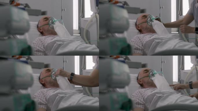 护士照顾戴着氧气面罩躺着的老年病人