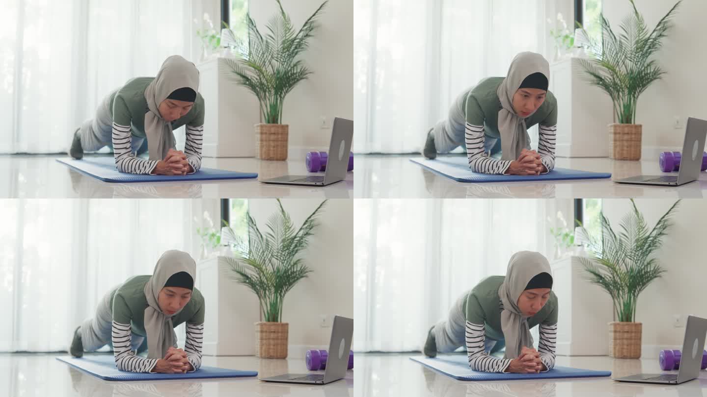 运动亚洲伊斯兰妇女穿穆斯林运动服锻炼平板支撑姿势重点核心肌肉初学者练习在线课程训练从笔记本电脑在家里