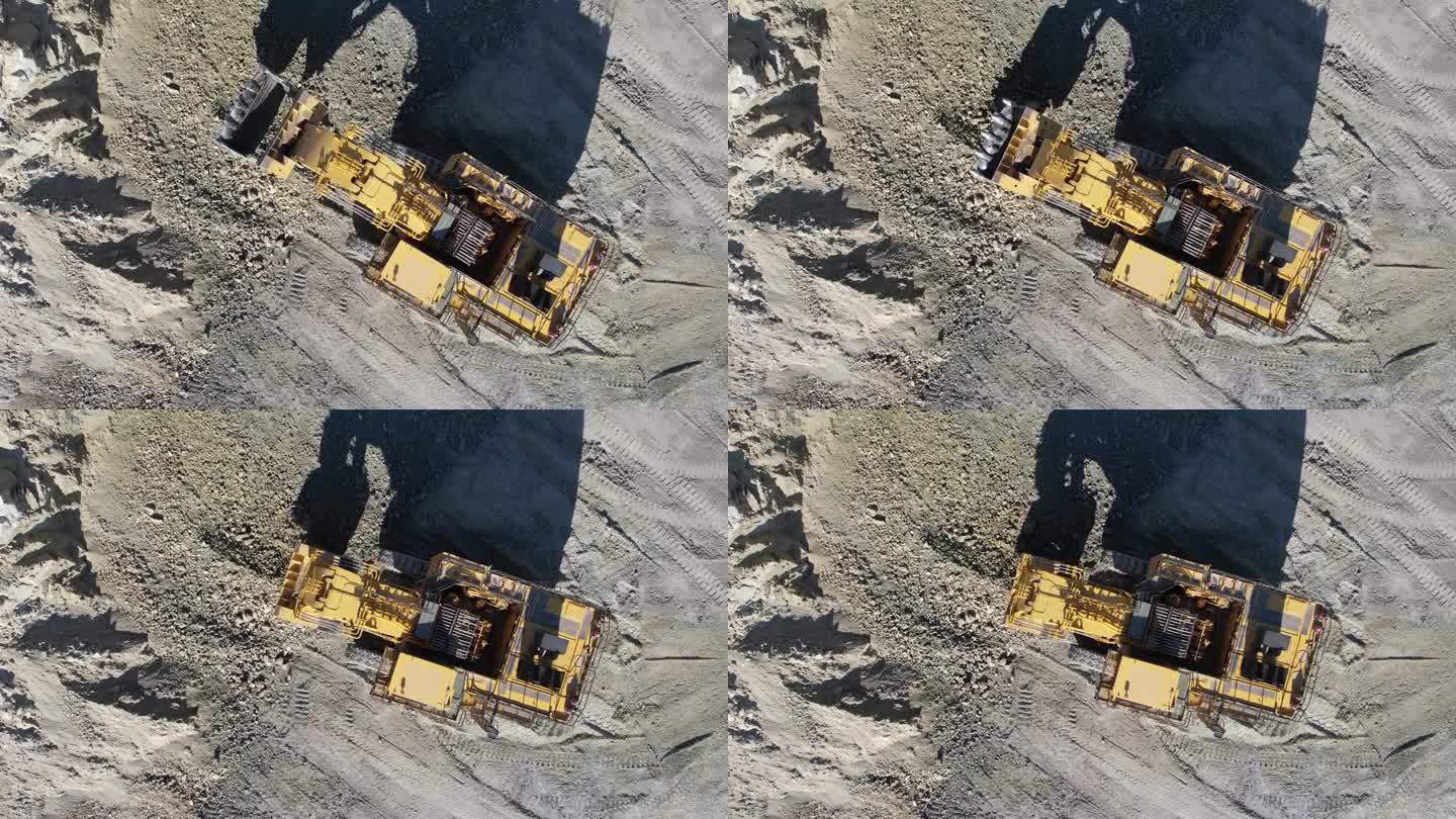 工作中的液压挖掘机在露天矿山挖矿，空中慢动作拍摄