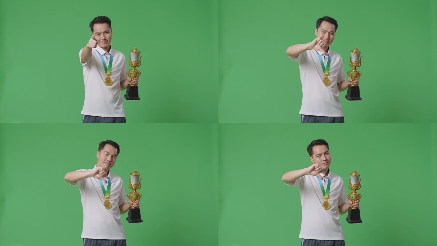 一个拿着金牌和奖杯的亚洲人指着绿屏背景嘲笑失败者