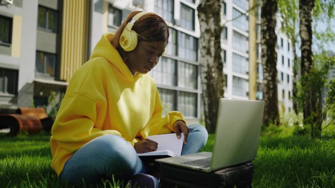 不同国家学生的在线教育，黑人女孩带着无线耳机和笔记本电脑
